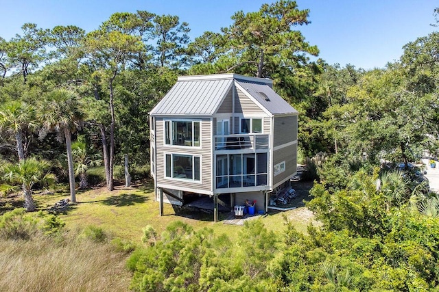 2473 High Hammock Rd, Seabrook Island, SC 29455 - back of property with a balcony, metal roof, and a lawn