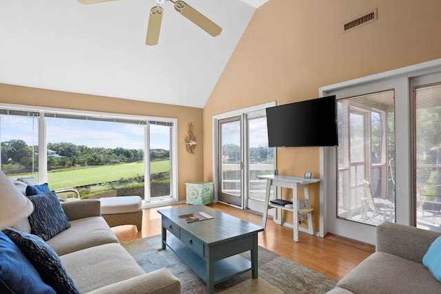 living room featuring ceiling fan, light wood-type flooring, and high vaulted ceiling