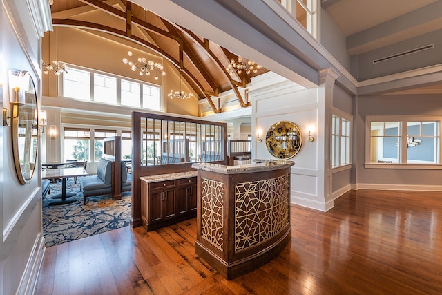 kitchen with dark wood-type flooring, high vaulted ceiling, a kitchen island, beamed ceiling, and a chandelier