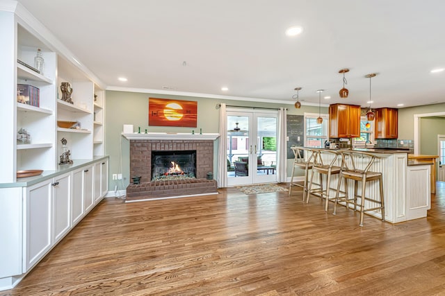 762 Swanson Ave, Charleston, SC 29412 - living area featuring ornamental molding, french doors, light wood finished floors, recessed lighting, and a brick fireplace