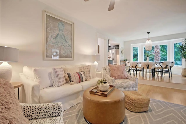 living room featuring wood-type flooring and ceiling fan