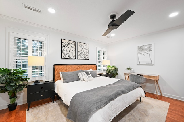 bedroom featuring light hardwood / wood-style flooring, ceiling fan, and ornamental molding