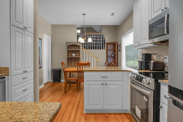 652 Spinner Cir, Mount Pleasant, SC 29464 - kitchen featuring appliances with stainless steel finishes, a chandelier, white cabinets, light wood finished floors, and a peninsula