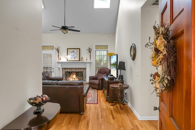652 Spinner Cir, Mount Pleasant, SC 29464 - living room featuring light wood-type flooring, a warm lit fireplace, a ceiling fan, and lofted ceiling