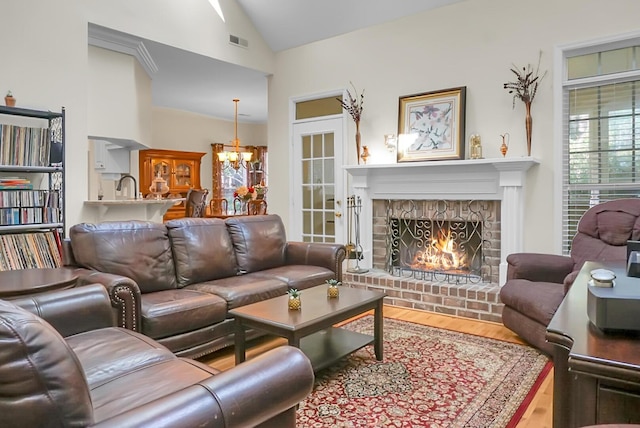 652 Spinner Cir, Mount Pleasant, SC 29464 - living area with wood finished floors, vaulted ceiling, a chandelier, and a brick fireplace