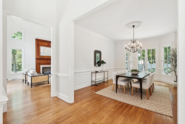 125 Drayton Dr, Summerville, SC 29483 - dining space featuring a fireplace, light wood-style floors, a chandelier, and ornamental molding