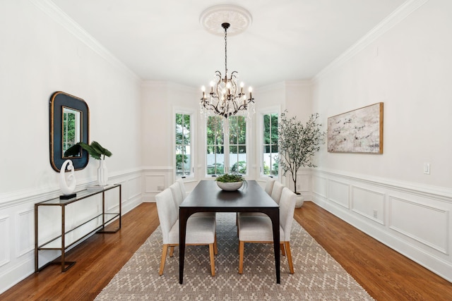 125 Drayton Dr, Summerville, SC 29483 - dining space with a chandelier, wood finished floors, a decorative wall, crown molding, and a wainscoted wall