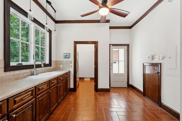 125 Drayton Dr, Summerville, SC 29483 - kitchen featuring a sink, baseboards, light countertops, ornamental molding, and tasteful backsplash