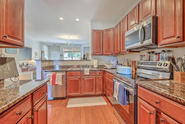 1723 Brittlebush Ln, Johns Island, SC 29455 - kitchen featuring stainless steel appliances, light wood-style floors, dark stone counters, a peninsula, and recessed lighting