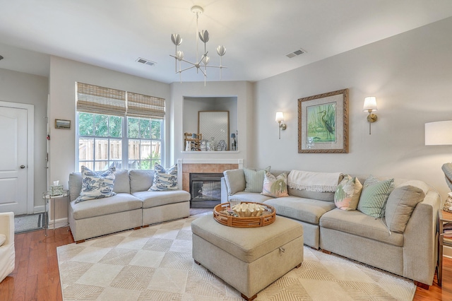 1723 Brittlebush Ln, Johns Island, SC 29455 - living room with a chandelier, light wood finished floors, and a tiled fireplace