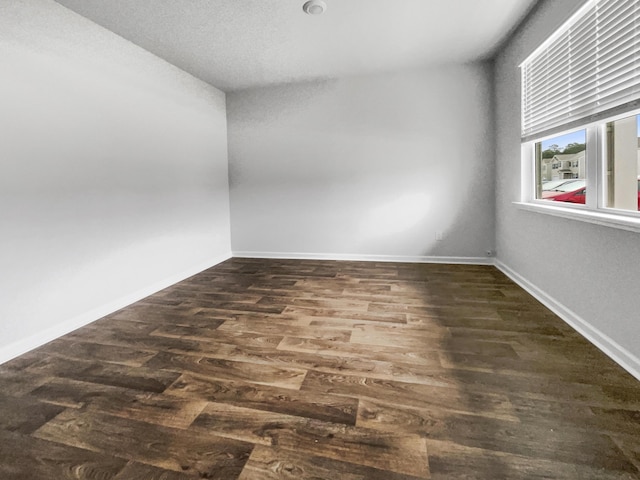 spare room featuring dark wood-type flooring