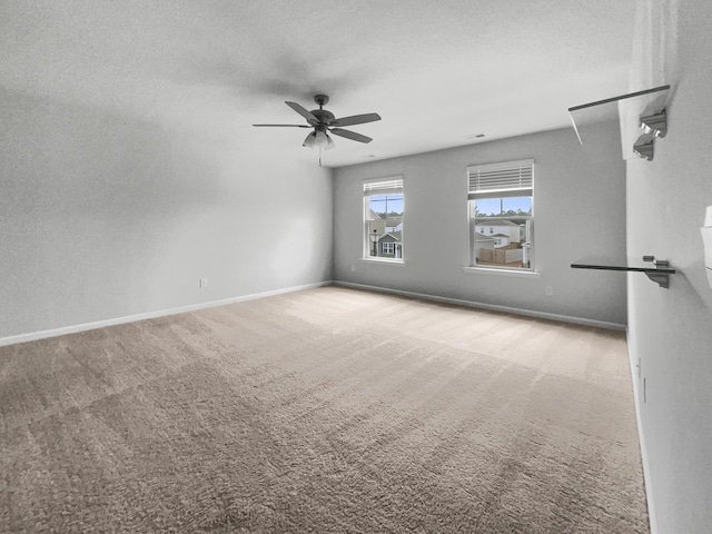 carpeted spare room featuring a textured ceiling and ceiling fan