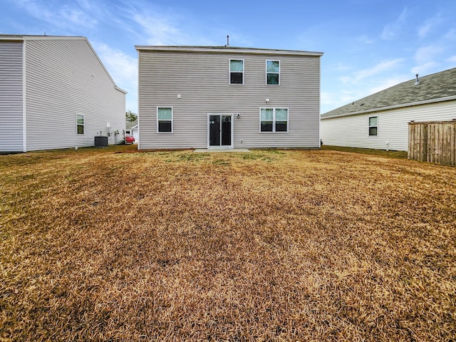 rear view of property with central AC and a lawn