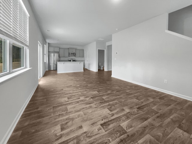 unfurnished living room with dark wood-type flooring