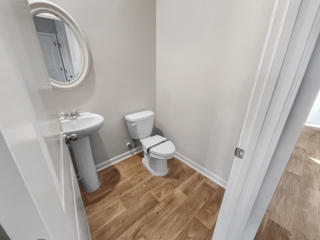 bathroom featuring toilet, hardwood / wood-style flooring, and sink