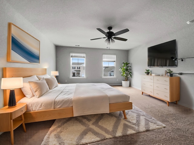 bedroom featuring ceiling fan, a textured ceiling, and carpet flooring