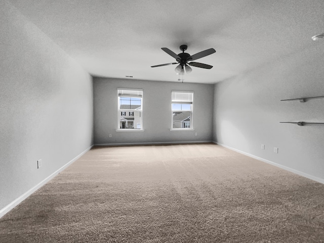 carpeted spare room featuring ceiling fan and a textured ceiling