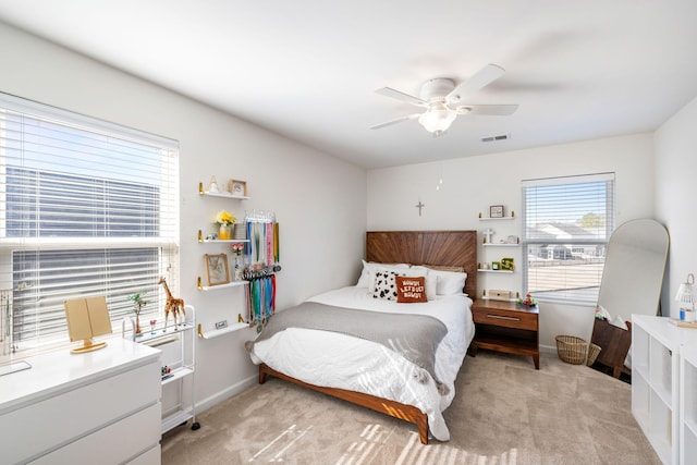 bedroom with ceiling fan, baseboards, visible vents, and light carpet