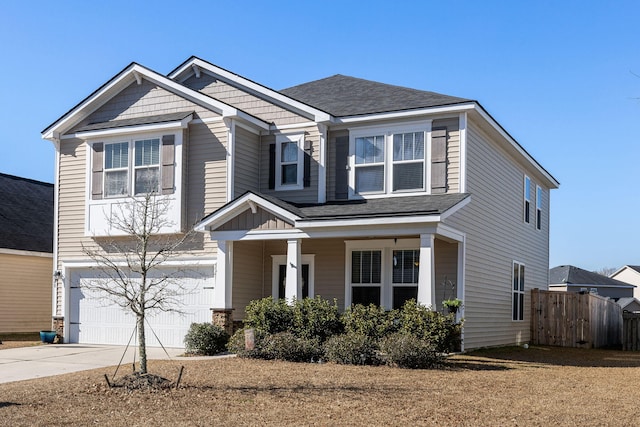 view of front of property featuring concrete driveway, fence, and a garage