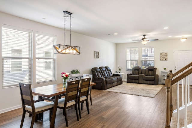 dining area with baseboards, stairway, recessed lighting, ceiling fan with notable chandelier, and wood finished floors