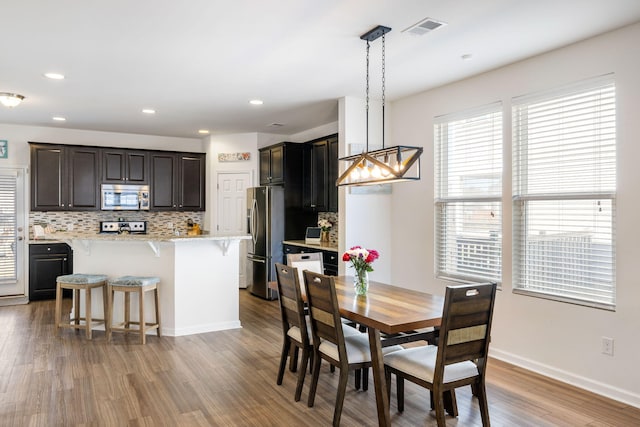 dining area with recessed lighting, visible vents, light wood finished floors, and baseboards