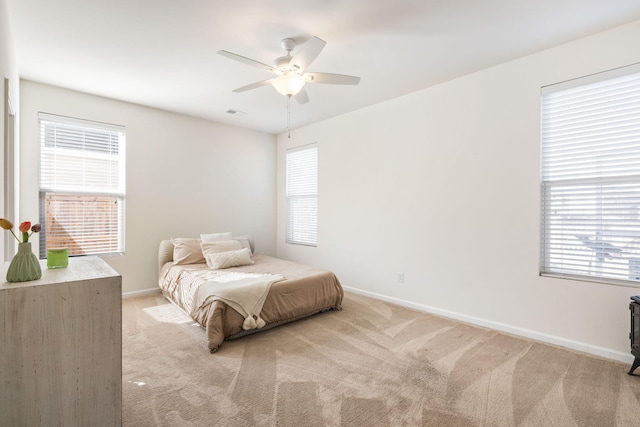 bedroom with baseboards, light colored carpet, and a ceiling fan