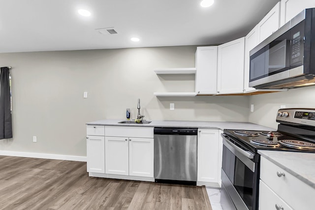 1979 Macon Ave, North Charleston, SC 29405 - kitchen with appliances with stainless steel finishes, a sink, light wood-type flooring, open shelves, and white cabinets