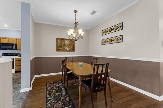 dining room featuring ornamental molding, dark wood-type flooring, a chandelier, and baseboards