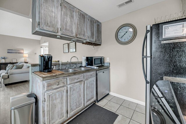202 Mariners Cay Dr, Folly Beach, SC 29439 - kitchen with stainless steel appliances, light tile patterned flooring, open floor plan, and dark countertops