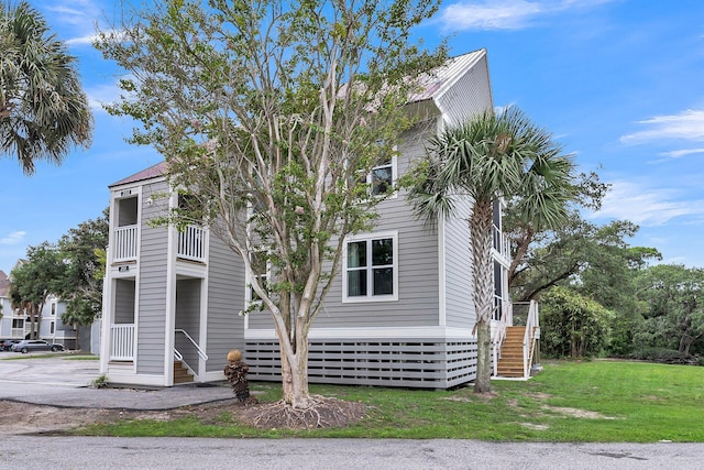 202 Mariners Cay Dr, Folly Beach, SC 29439 - view of front of home with stairs, a front yard, and a balcony