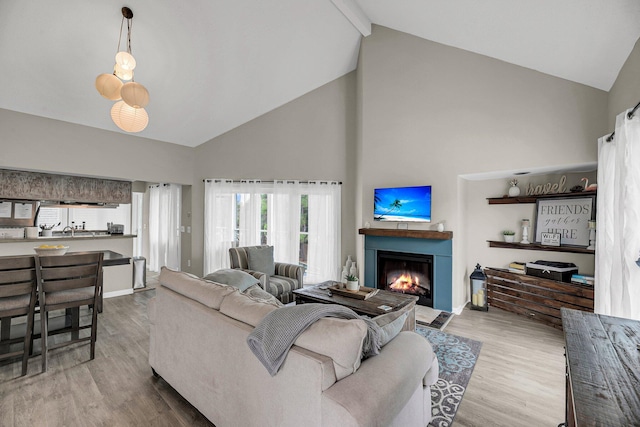 202 Mariners Cay Dr, Folly Beach, SC 29439 - living room with high vaulted ceiling, a lit fireplace, wood finished floors, and beamed ceiling