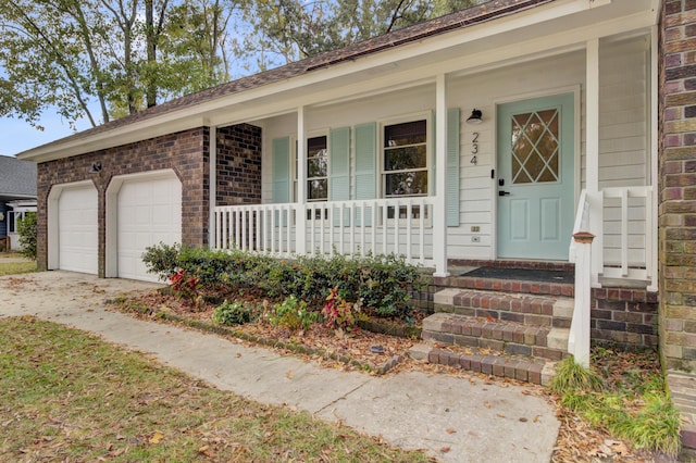 view of exterior entry featuring covered porch and a garage