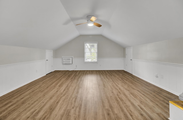 bonus room featuring ceiling fan, lofted ceiling, light hardwood / wood-style flooring, and a wall mounted air conditioner