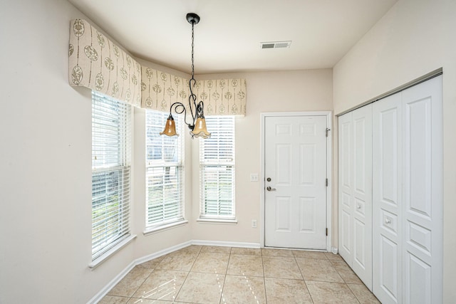 tiled foyer entrance with a notable chandelier