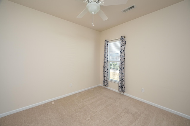 empty room with ceiling fan and light carpet