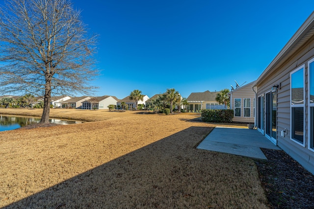 view of yard featuring a patio area and a water view