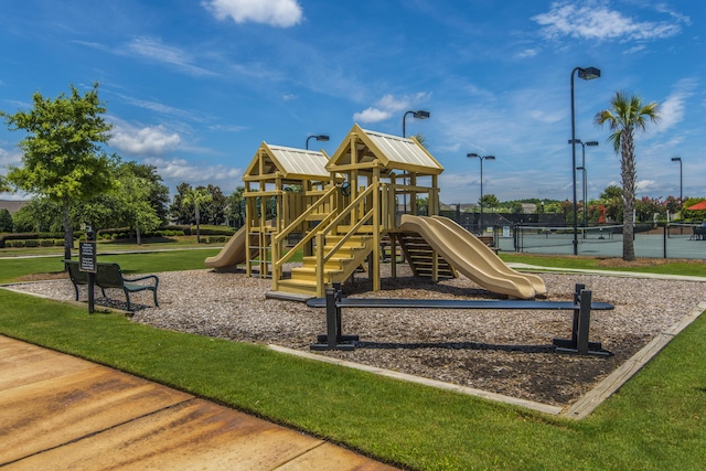 view of jungle gym featuring tennis court