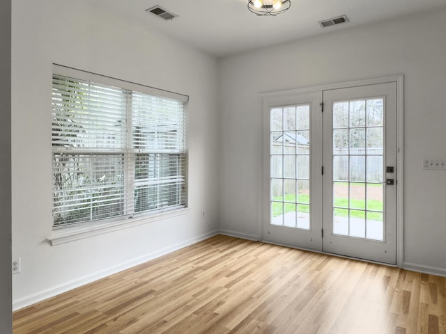 doorway to outside with baseboards, visible vents, and wood finished floors