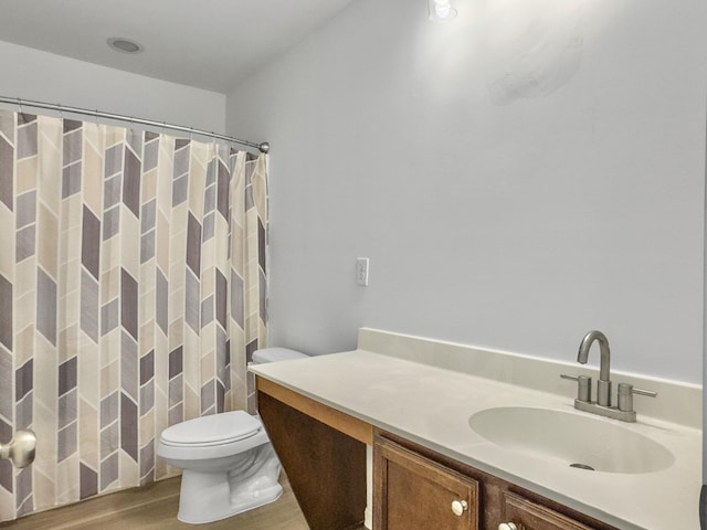 bathroom featuring a shower with shower curtain, vanity, toilet, and wood finished floors