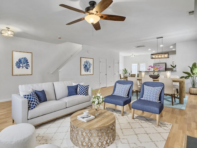 living area with recessed lighting, baseboards, visible vents, and light wood finished floors