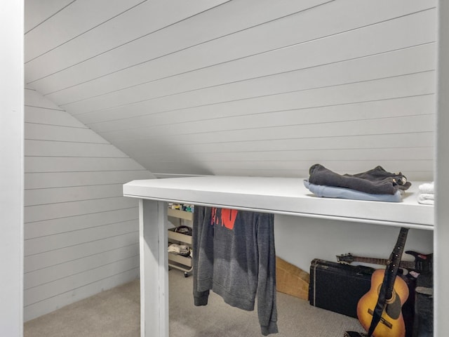 bathroom with lofted ceiling and wooden walls