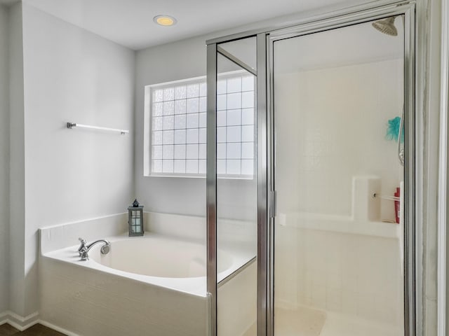 bathroom featuring a stall shower and a garden tub