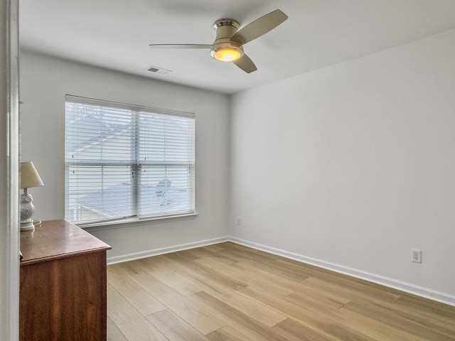 unfurnished room featuring light wood-style floors, visible vents, baseboards, and a ceiling fan