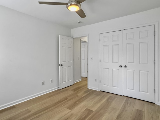 unfurnished bedroom with a closet, baseboards, ceiling fan, and light wood finished floors