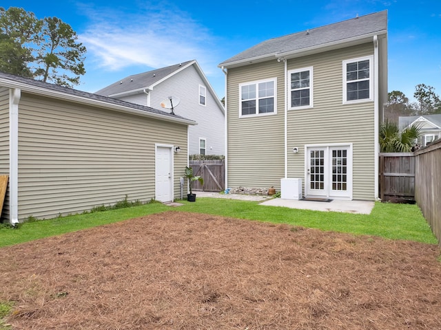 back of property with a fenced backyard, a lawn, and a patio