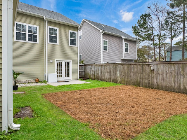 rear view of property with fence, a lawn, and a patio