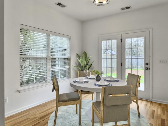 dining area with a wealth of natural light, light wood-type flooring, and visible vents