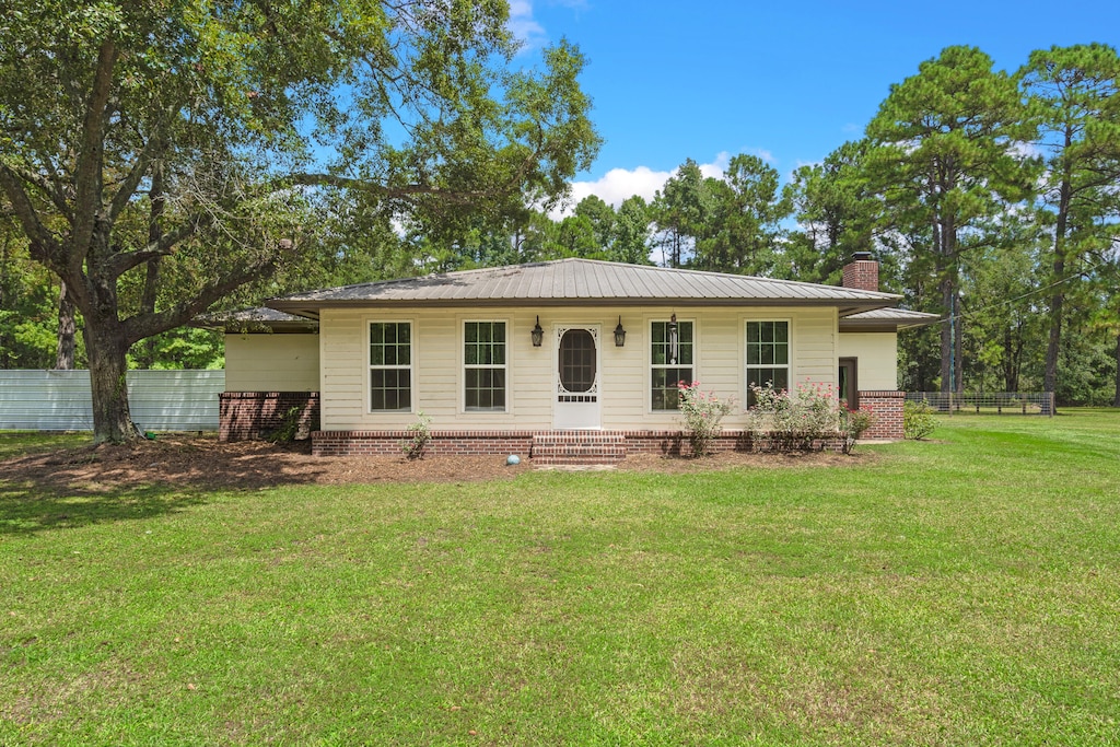 rear view of house featuring a yard