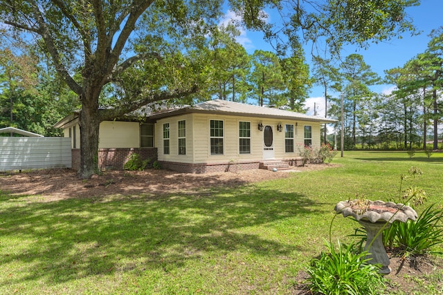 rear view of property featuring a lawn