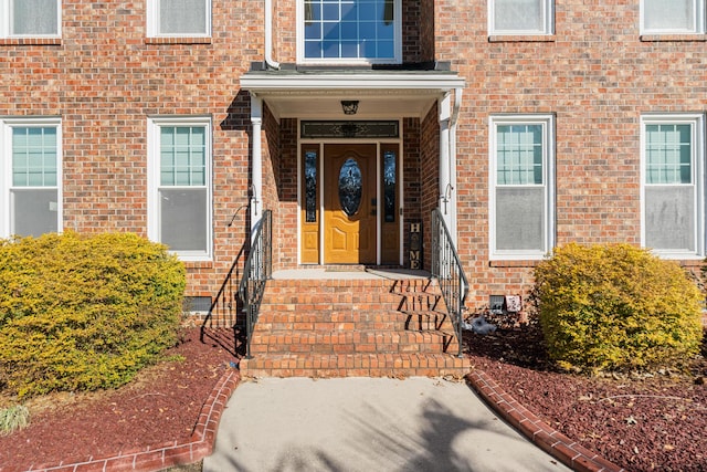 view of exterior entry featuring crawl space and brick siding